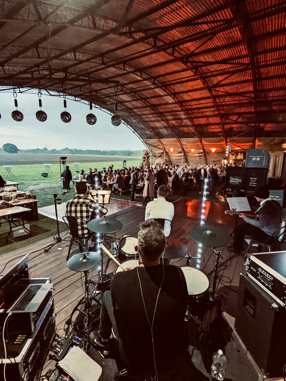 The band set up in an open-sided barn looking out over fields