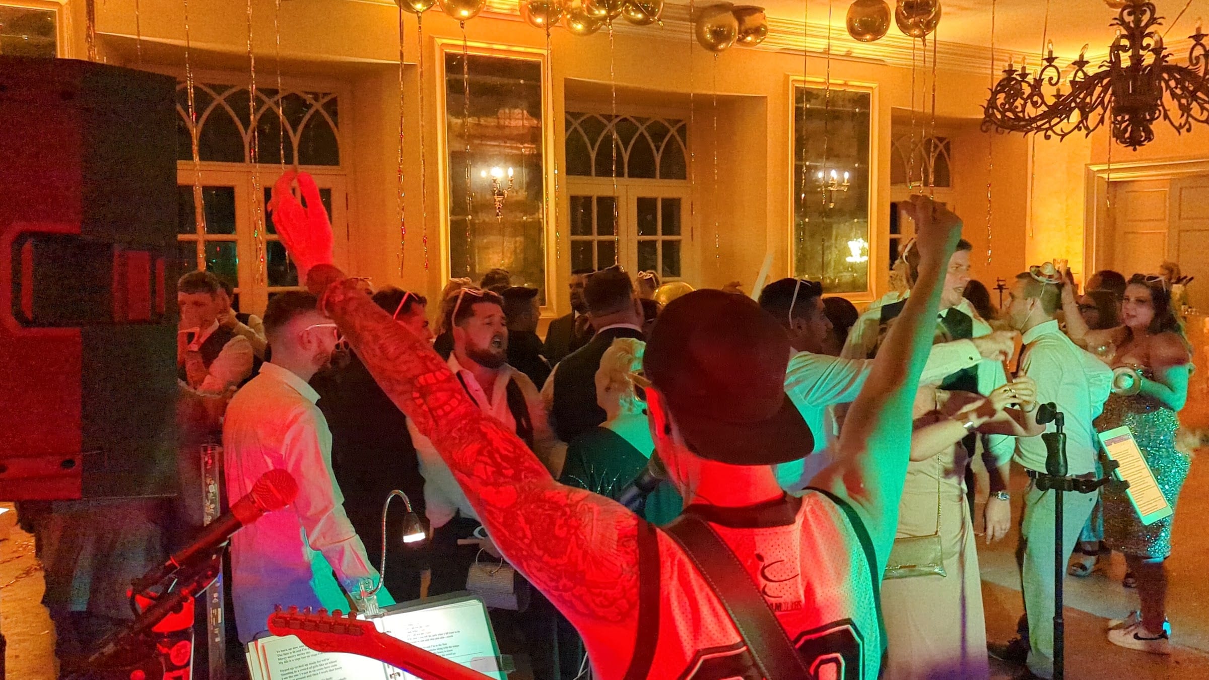 Arms in the air in a gold-lit function room