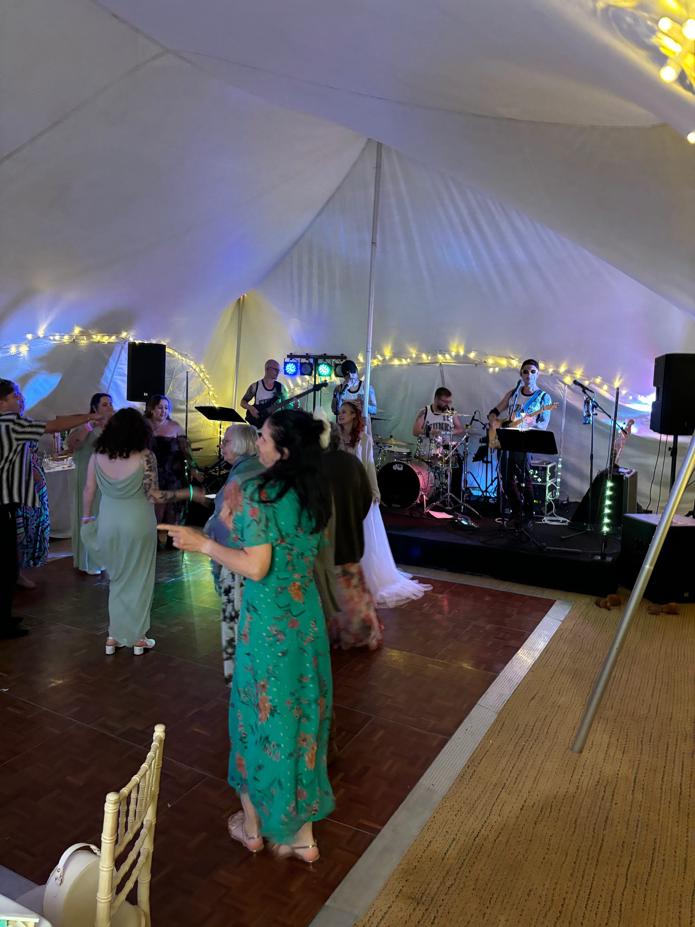 Guests dancing in a marquee strung with festoon lights