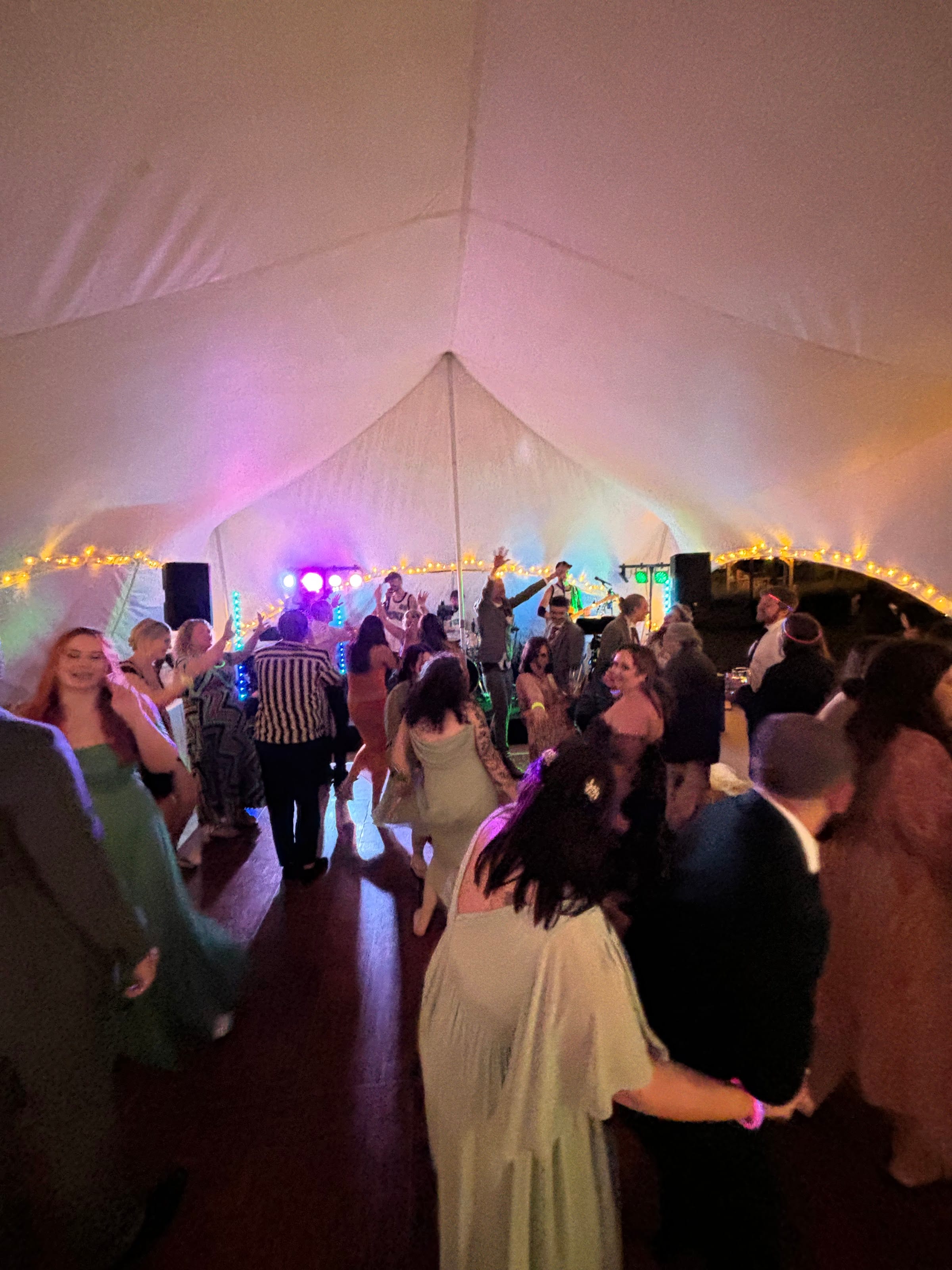 A full marquee dancefloor with the band playing behind it