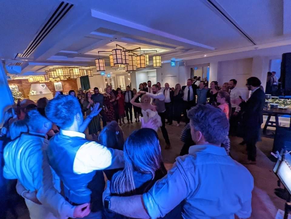 Guests dancing shoulder to shoulder under blue light