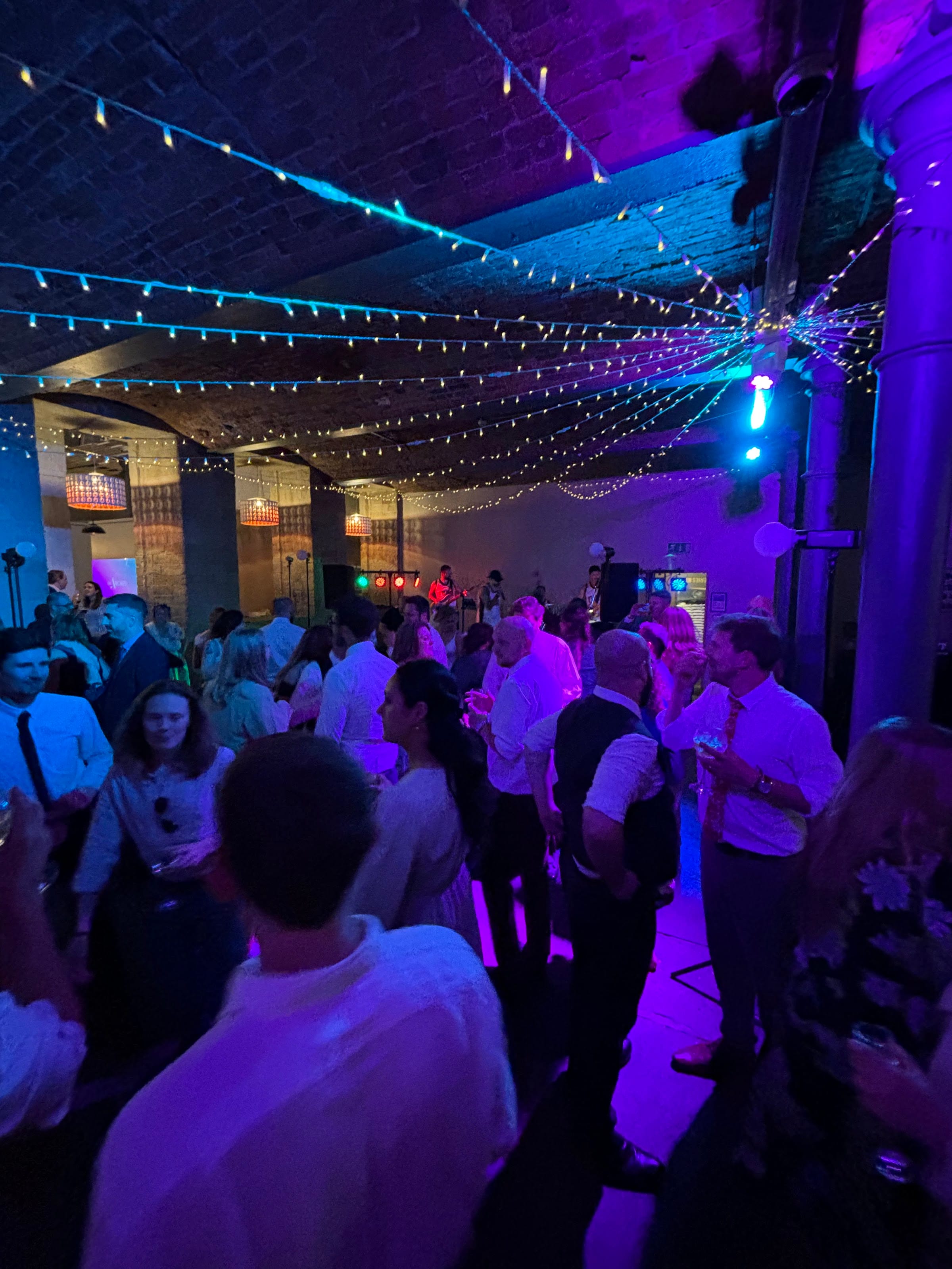 A busy dancefloor beneath a canopy of festoon lights